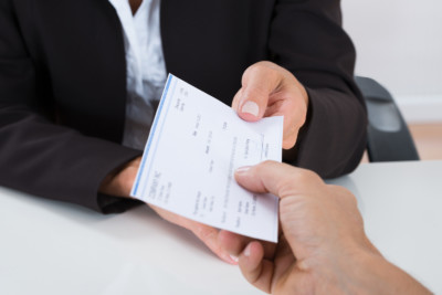 Businessperson Hands Giving Cheque To Other Person